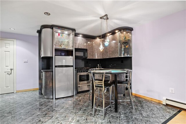 kitchen featuring appliances with stainless steel finishes, decorative light fixtures, sink, backsplash, and a baseboard heating unit