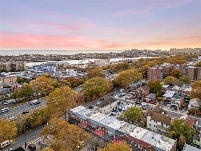 aerial view at dusk featuring a water view