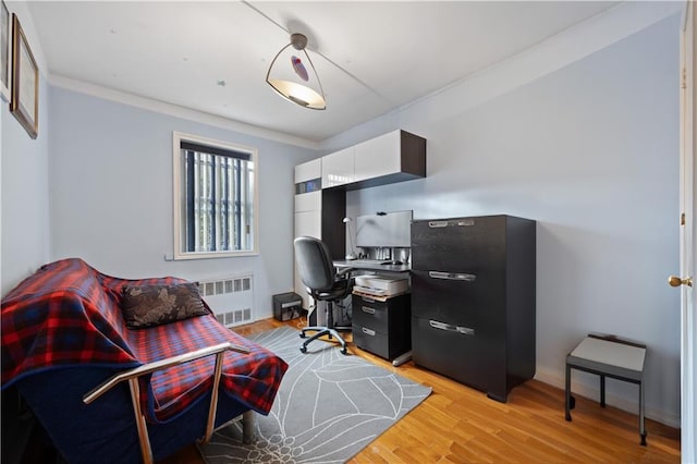 office area with ornamental molding, radiator heating unit, and light hardwood / wood-style flooring