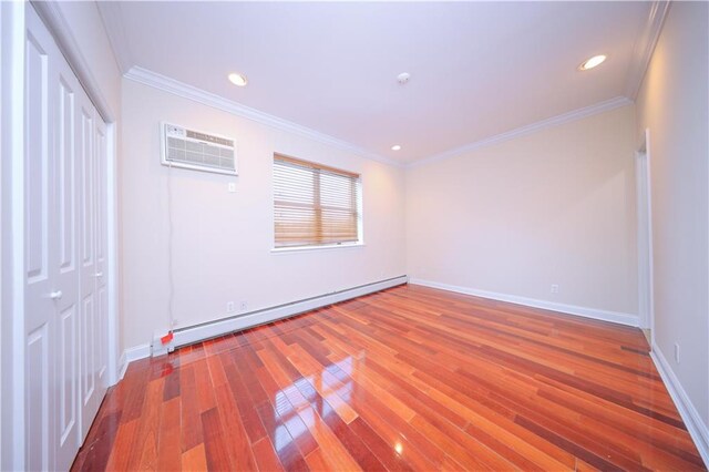 unfurnished bedroom featuring crown molding, a baseboard heating unit, and hardwood / wood-style flooring