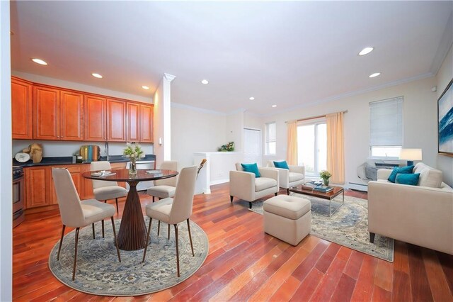 dining area featuring wood-type flooring and crown molding