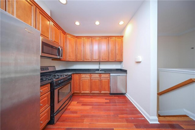 kitchen with wood-type flooring, appliances with stainless steel finishes, and sink