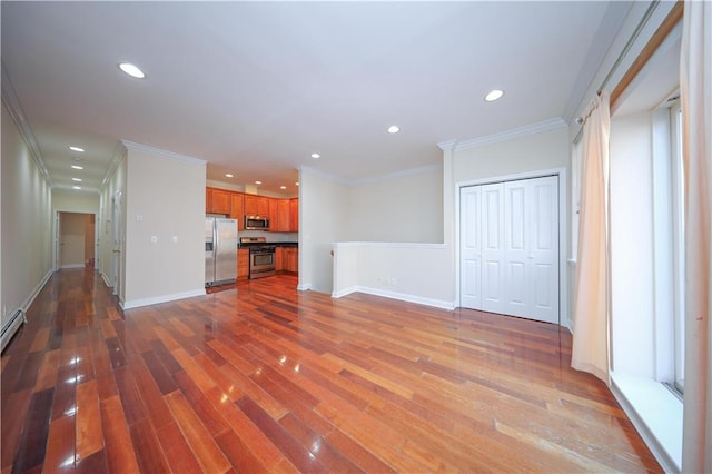 unfurnished living room featuring recessed lighting, ornamental molding, baseboards, and wood finished floors