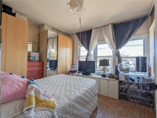 bedroom featuring dark parquet flooring