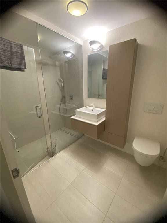 bathroom featuring tile patterned flooring, vanity, toilet, and a shower with shower door