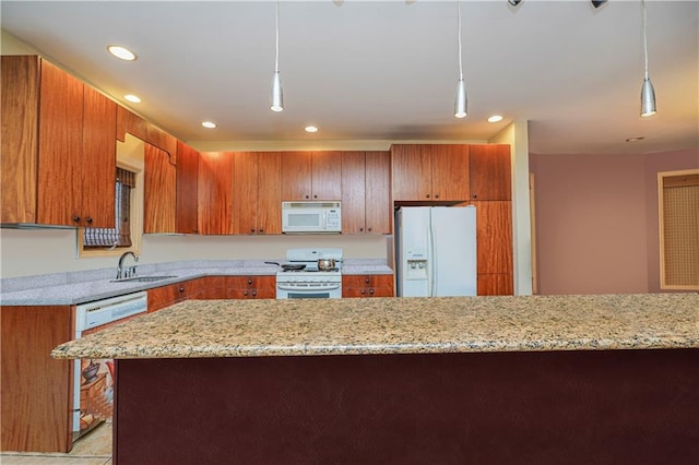 kitchen featuring light stone countertops, white appliances, sink, and hanging light fixtures