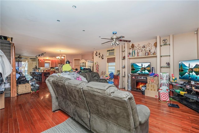 living room featuring ceiling fan with notable chandelier and wood-type flooring