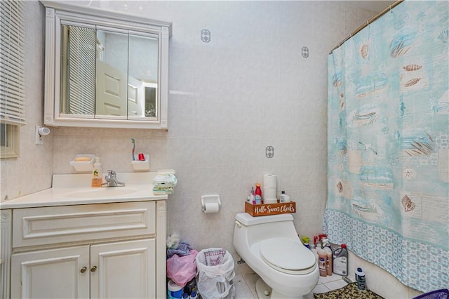 bathroom with vanity, tile patterned flooring, toilet, and tile walls