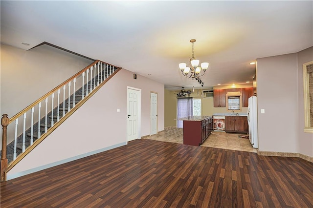 kitchen featuring sink, white refrigerator, an inviting chandelier, and hardwood / wood-style flooring