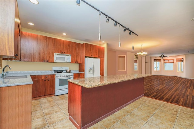 kitchen with light hardwood / wood-style floors, sink, ceiling fan with notable chandelier, decorative light fixtures, and white appliances