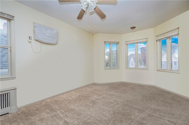 carpeted spare room featuring ceiling fan