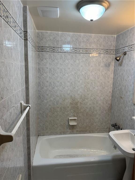2069 E 55th St, Brooklyn, NY 11234 - bathroom featuring tile walls and bathing tub / shower combination
