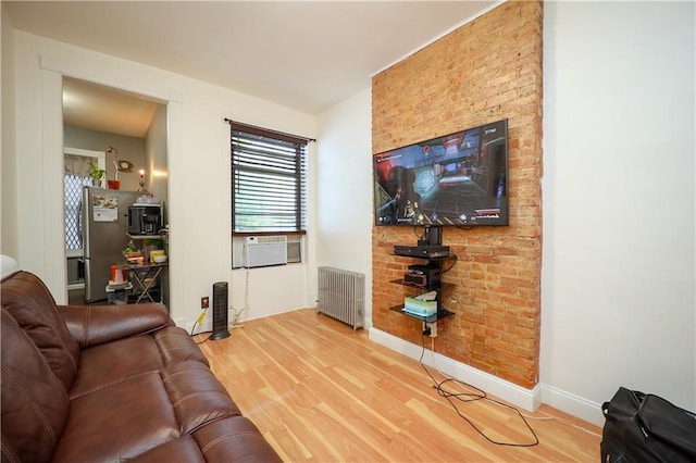 living room with hardwood / wood-style floors, cooling unit, and radiator