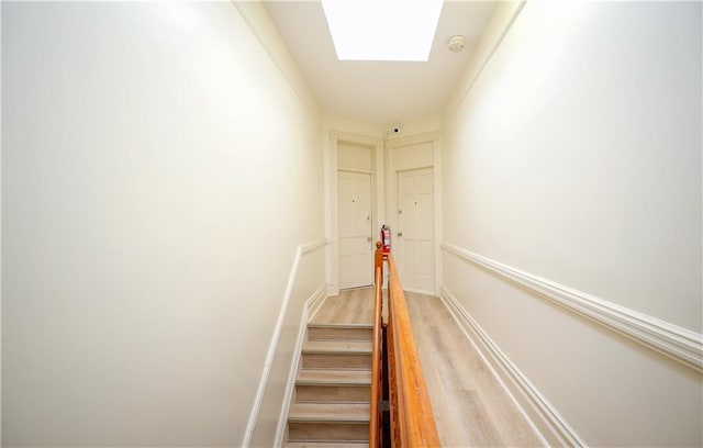 staircase featuring hardwood / wood-style floors and a skylight