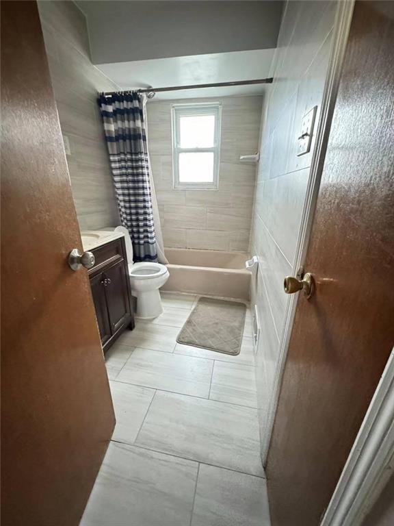 bathroom with shower / tub combo, vanity, and toilet