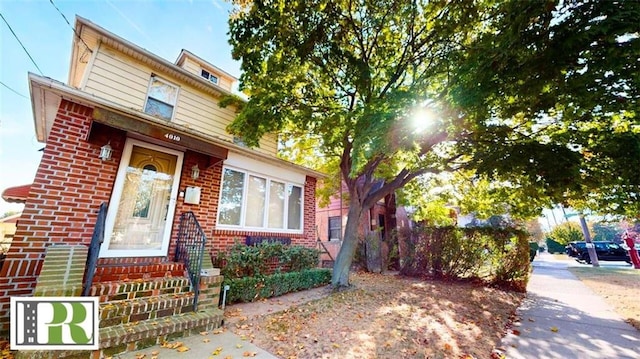 american foursquare style home with brick siding