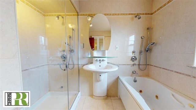 bathroom with tile patterned floors, tile walls, and a combined bath / shower with jetted tub