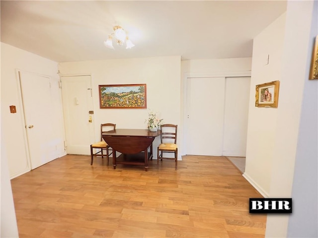 dining area featuring light wood-type flooring and a notable chandelier