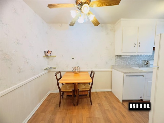 dining space featuring light hardwood / wood-style floors, ceiling fan, and sink