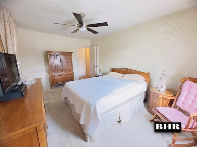 bedroom with a ceiling fan and light colored carpet