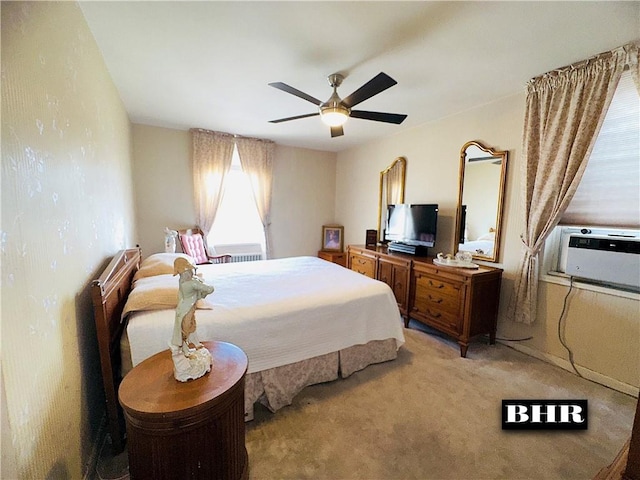 bedroom with a wall mounted AC, a ceiling fan, and light colored carpet