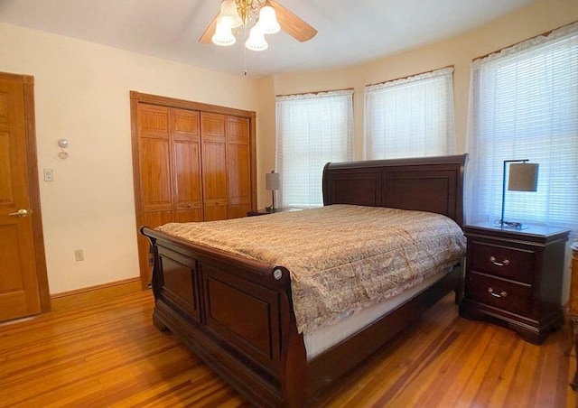 bedroom with a closet, ceiling fan, and light hardwood / wood-style floors