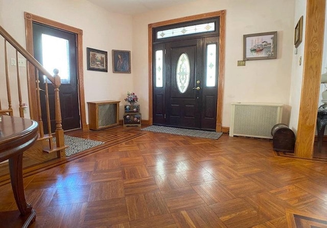 foyer entrance featuring radiator and dark parquet flooring