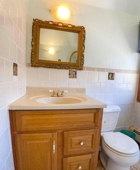 bathroom featuring tile walls, vanity, and toilet