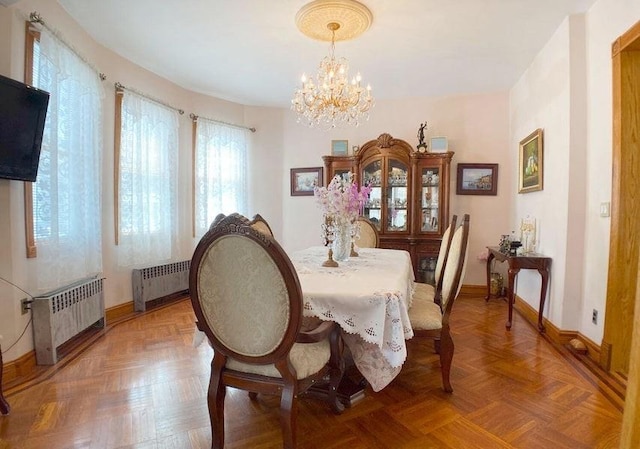 dining space featuring radiator heating unit, parquet floors, and a chandelier