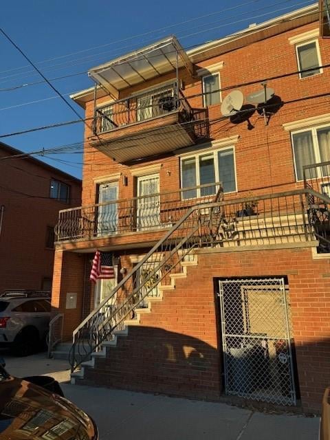 view of front facade with brick siding and stairway