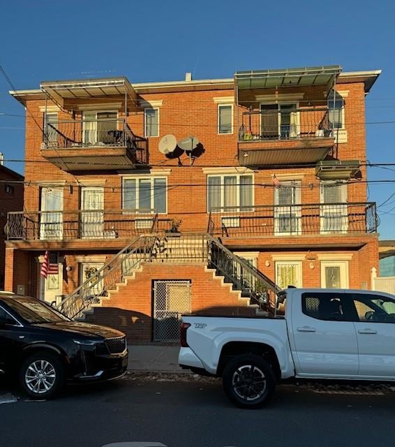 view of front facade with stairs and brick siding