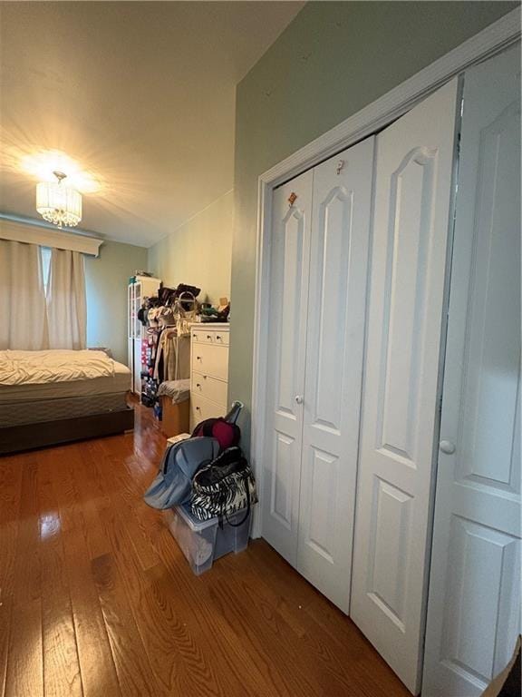 bedroom with hardwood / wood-style floors, a chandelier, and a closet