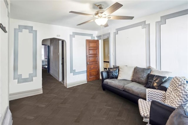 living room with dark parquet flooring and ceiling fan