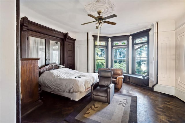 bedroom with ceiling fan and dark parquet floors