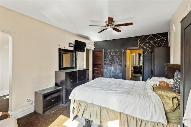 bedroom featuring ceiling fan and dark parquet flooring