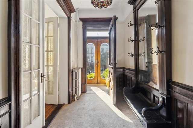 doorway featuring radiator, french doors, carpet floors, and ornamental molding