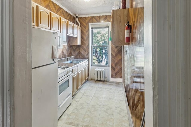 kitchen featuring white appliances, radiator heating unit, and sink