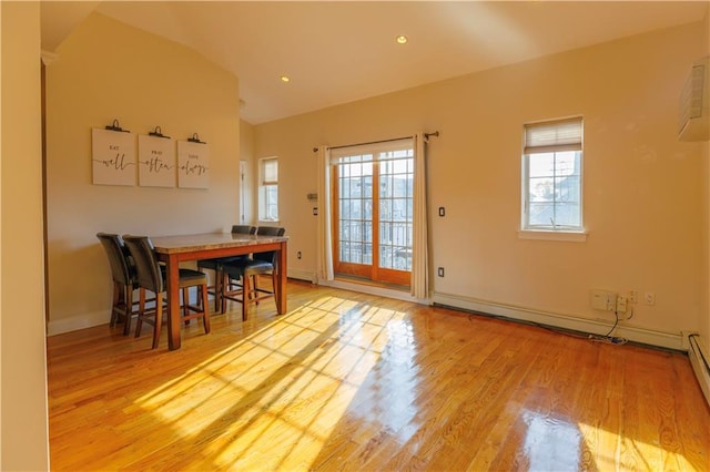 dining space with light wood finished floors, a baseboard radiator, lofted ceiling, recessed lighting, and baseboards