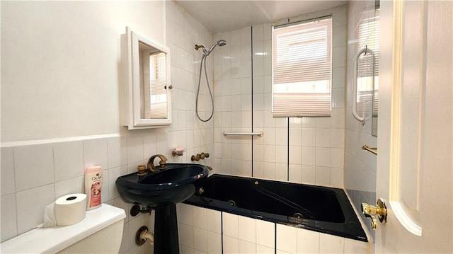 full bathroom featuring toilet, sink, tiled shower / bath combo, and radiator heating unit