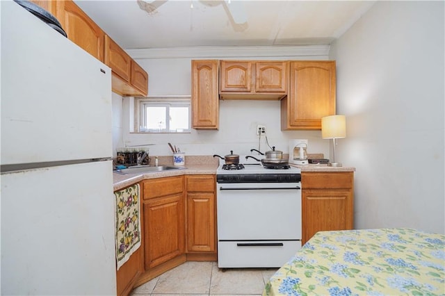 kitchen with ceiling fan, sink, white appliances, and light tile patterned floors