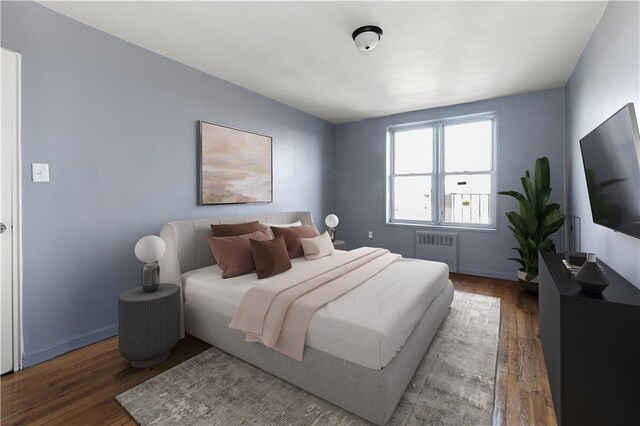 bedroom with dark wood-type flooring and radiator heating unit