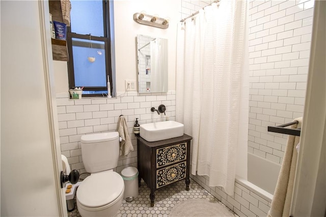 full bathroom featuring tile patterned floors, toilet, shower / tub combo, tile walls, and vanity