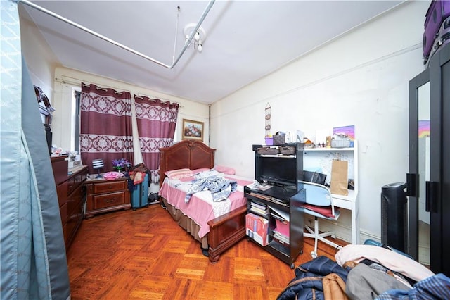 bedroom featuring dark parquet floors and rail lighting