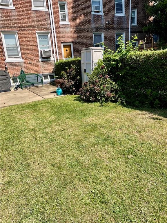 view of yard featuring cooling unit, a patio area, and a storage shed