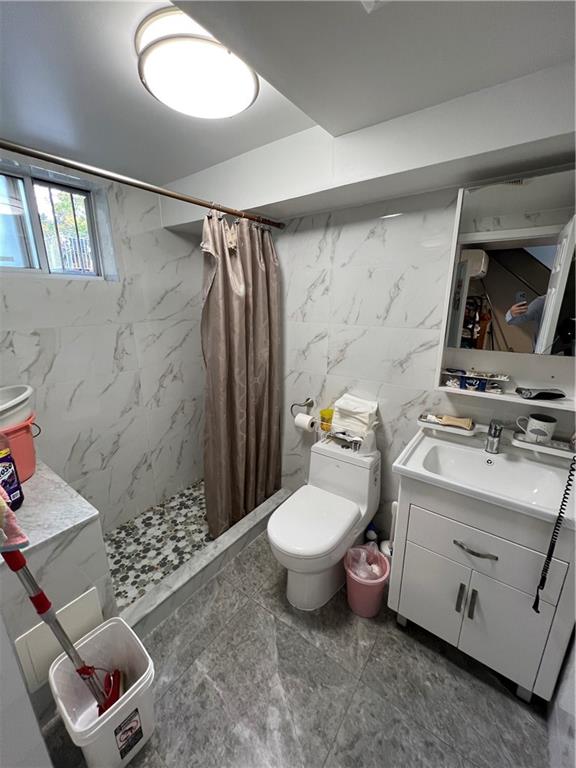 bathroom featuring tile walls, toilet, vanity, and a shower with shower curtain