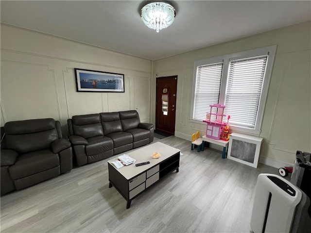 living room featuring heating unit and light hardwood / wood-style floors