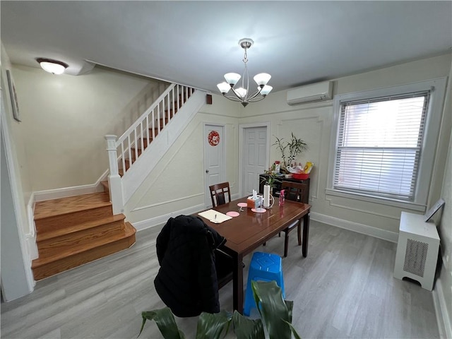 dining room with wood-type flooring, heating unit, a notable chandelier, and a wall mounted AC