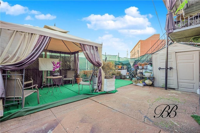 view of patio featuring a storage shed and a gazebo