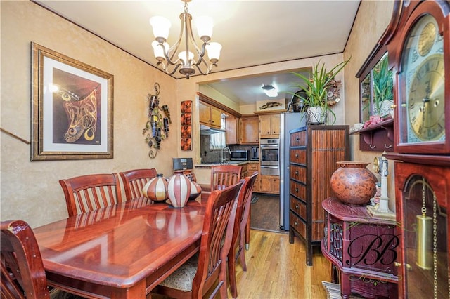 dining room with an inviting chandelier and light hardwood / wood-style flooring