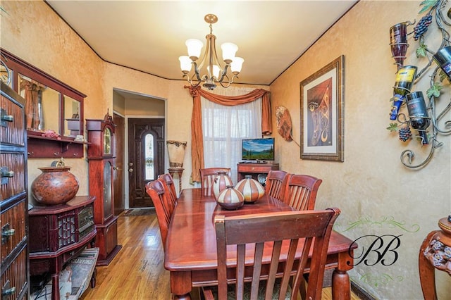 dining room with hardwood / wood-style flooring, crown molding, and a chandelier